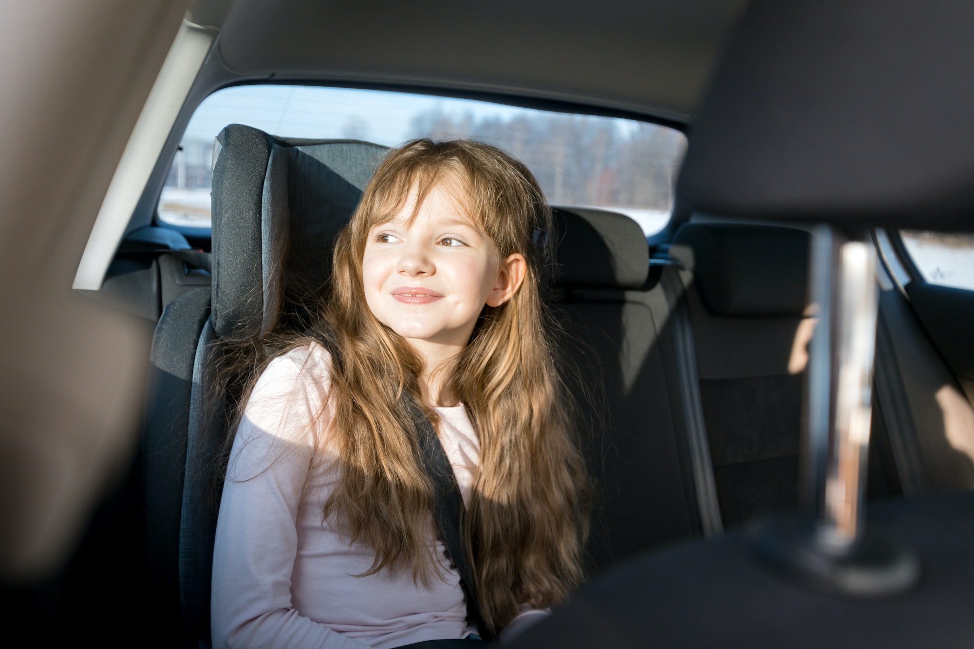 Happy little girl in child car seat